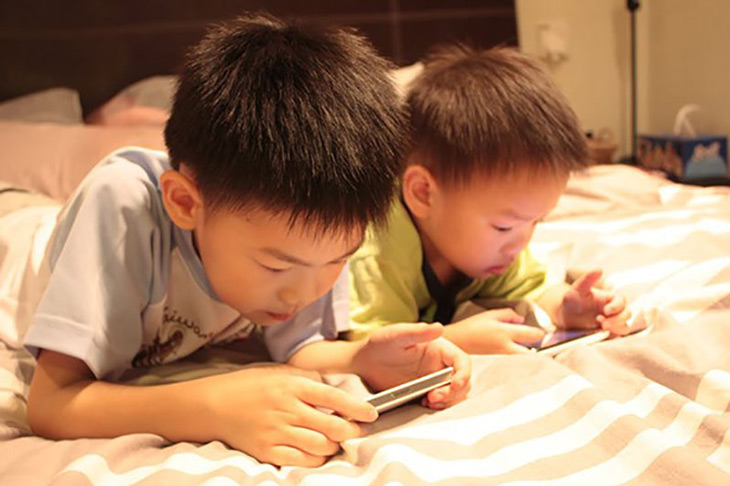 Cho trẻ chơi điện thoại là một trong những nguyên nhân khiến trẻ khó ngủ